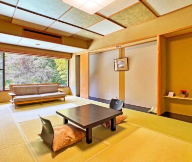 Tatami room at Honjin in Shizuoka with low wooden table, zabuton cushions and window overlooking greenery