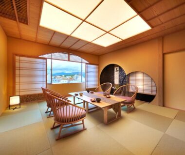 Traditional tatami room with low table, woven chairs, shoji screens and large window with distant mountain view