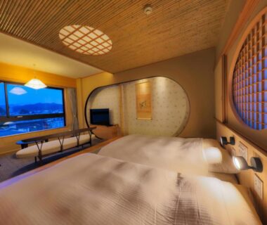 Tatami room with two beds and circular window framing mountains, Honjin Hiranoya Kofukan, Gifu Chubu Japan