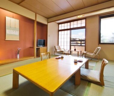 Traditional tatami room with low wooden table, shoji screens and seating by window at Honjin Hiranoya Kofukan, Gifu