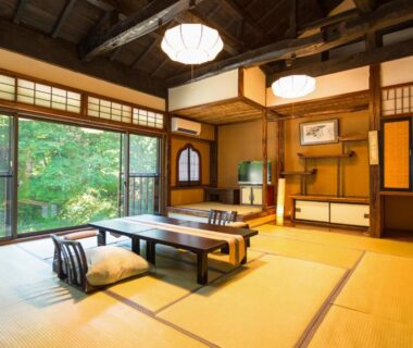 Spacious tatami room with low table, shoji screens and garden view at Honke Bankyu in Tochigi