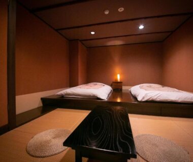 Minimal tatami room with futon bedding, low table and floor cushions at Hosenji Kanko Hotel Yumotoya in Oita, Kyushu