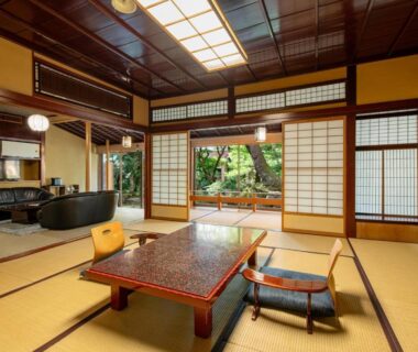 Traditional tatami room with low table, zabuton chairs, shoji screens and garden view at Hoshi in Ishikawa