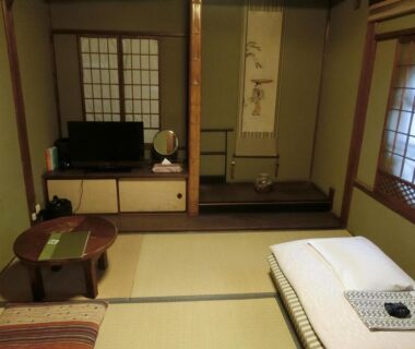 Traditional tatami room with futon, low table, shoji screens and tokonoma at Hoshidekan in Mie