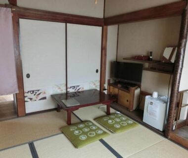 Tatami room with low table, cushions and fusuma doors at Hoshidekan in Mie