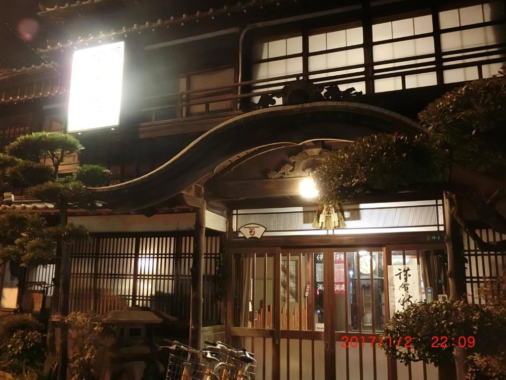 Nighttime ryokan entrance Hoshidekan Mie Illuminated traditional wooden entrance with sliding lattice doors at Hoshidekan in Mie, Kansai