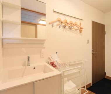 Bright wash basin with mirror, wall-mounted hangers and shelving in ryokan room at Hot Spring Inn Hakone Suisen Kanagawa