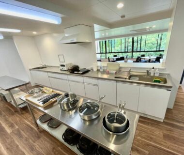 Communal kitchen with stainless counters, cookware, and seating at Hot Spring Inn Hakone Suisen in Kanagawa