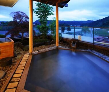 Outdoor onsen bath overlooking river and mountains at Hot spring inn Snow country, Niigata