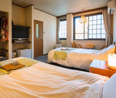 Western-style twin beds in shoji-lined room at Hotaru no Yado Sendou, Ōita, Kyūshū