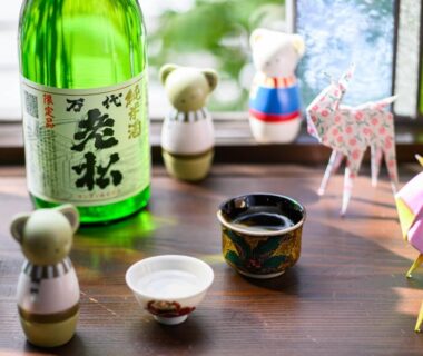 Sake bottle and cups with origami decorations on a wooden windowsill at Hotel Asyl Nara