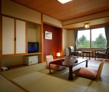 Tatami room at Hotel Daiheigen in Hokkaido with low table, floor cushions and sliding shoji doors