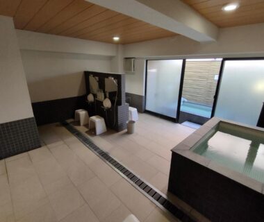 Indoor bathing area with soaking tub and washing stools, Hotel Edoya, Tokyo
