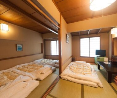 Tatami room with futons, shoji screens and low table at Hotel Edoya in Tokyo