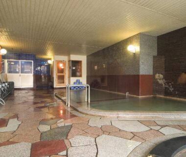 Spacious indoor bath with tiled floor and shower stations at Hotel Grand Toya, Hokkaidō Japan