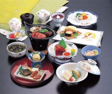 Assorted small Japanese dishes on lacquer trays and bowls at Hotel Grand Toya in Hokkaidō ryokan
