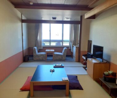 Tatami room with low table, cushions and window seating at Hotel Grand Toya in Hokkaido, Japan