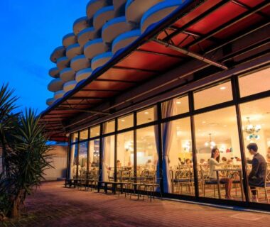 Evening dining room behind glass facade at Hotel Green Plaza Hamanako in Shizuoka