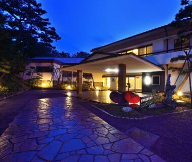 Stone path and illuminated entrance of Hotel Hagoromo at dusk in Shizuoka, Chūbu, Japan