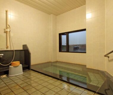 Tiled indoor bath with stools and hand shower at Hotel Hana Isawa Yamanashi