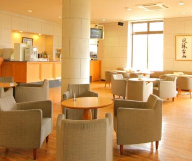 Bright lounge with upholstered chairs and tables at Hotel Hana Isawa in Yamanashi