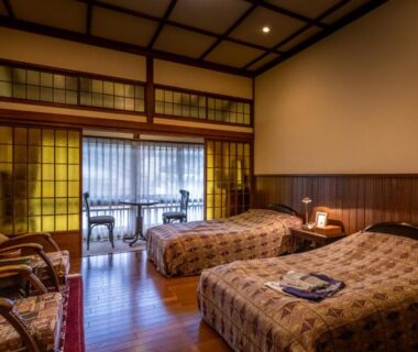 Twin Western-style beds, shoji screens and seating at Hotel Hanakoyado in Hyōgo, Kansai