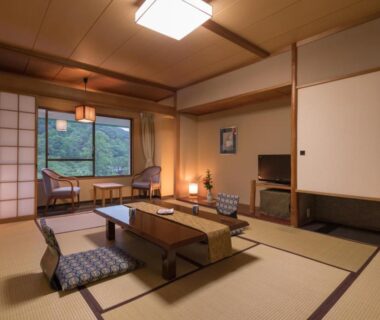 Traditional tatami room with low table, zabuton cushions and shoji screens at Hotel Hanamaki, Iwate, Tōhoku