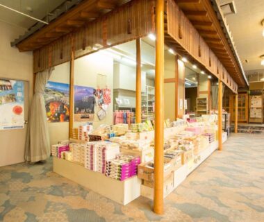 Indoor souvenir display with packaged gifts and posters at Hotel Heian lobby, Yamanashi, Chūbu region