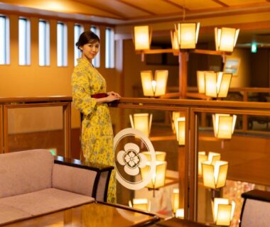 Lobby lounge with wooden railings, lanterns and attendant in yukata at Hotel Hoho, Niigata