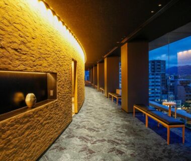 Elegant illuminated corridor with city views and benches at Hotel Honnoji in Kyoto, Kansai