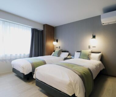 Modern twin bedroom with green bed runners at Hotel Ichibokaku, Nagano, Chūbu