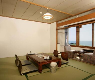 Tatami room with low table and sea view at Hotel Izumi in Hokkaidō, Japan