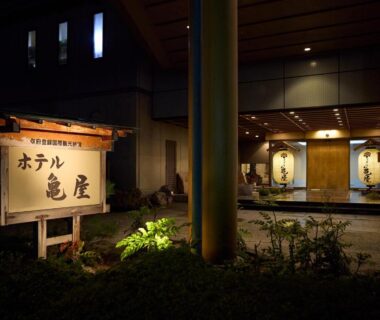 Warmly lit entrance with wooden sign at Hotel Kameya in Miyagi, Tōhoku