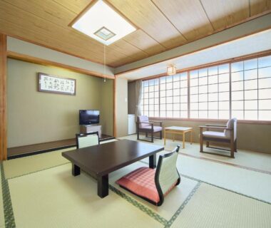 Traditional tatami room with low table, cushions, shoji screens and window seating at Hotel Kameya in Miyagi