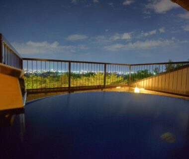 Wooden outdoor onsen bath on balcony under starry sky at Hotel Kaminoyu in Yamanashi, Chūbu
