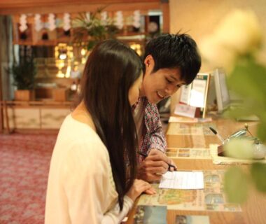 Couple checking in at ryokan reception desk Hotel Kaminoyu Onsen Yamanashi