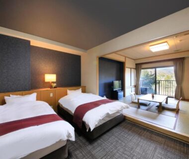 Twin beds, tatami seating area and balcony at Hotel Kamogawaso, Hiroshima, Chūgoku, Japan