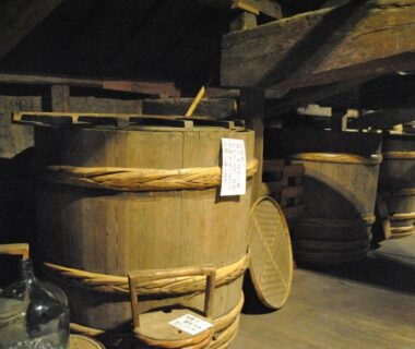 Rows of wooden storage barrels in a dim cellar at Hotel Kazahaya, Ōita, Kyūshū, Japan