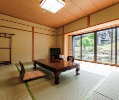 Traditional tatami room with low wooden table and garden view at Hotel Kikori in Gifu