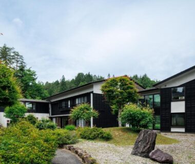 Low wooden ryokan exterior with gravel path and landscaped shrubs at Hotel Kikori in Gifu, Chubu, Japan
