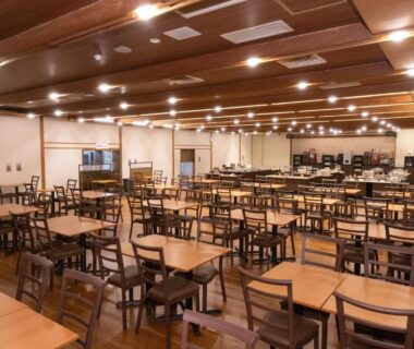 Large wooden dining hall with rows of tables and chairs at Hotel Kimiyoshi in Yamanashi Chūbu