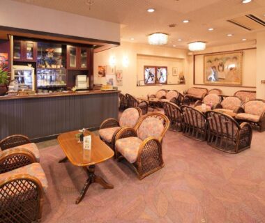 Warm lounge with wicker armchairs, low tables and bar counter at Hotel Kimura in Gunma