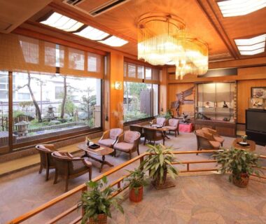 Spacious lounge with wooden ceiling, low seating and garden view at Hotel Kimura in Gunma, Kantō