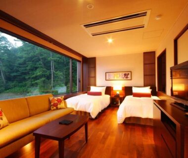 Twin beds, sofa and wooden floor by large forest-view window at Hotel Kinparo, Hyōgo, Kansai