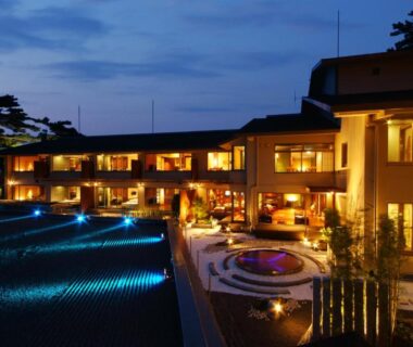 Dusk lit ryokan exterior with courtyard fountain and blue-lit pool, Hotel Kinparo, Hyōgo, Kansai Japan