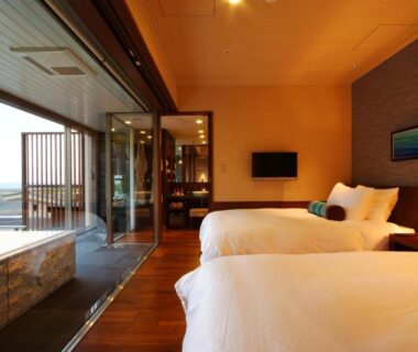 Twin beds, wooden floor and balcony stone bath at Hotel Kinparo in Hyōgo, Kansai, Japan