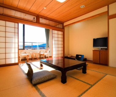 Tatami room with low table and shoji screens at Hotel Kinu in Tochigi
