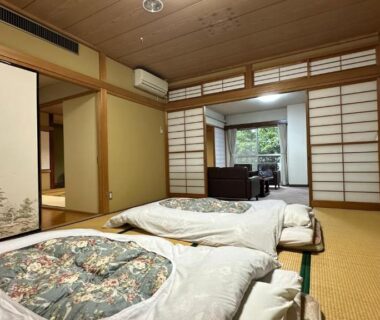 Traditional tatami room with futon bedding, shoji screens and garden view at Hotel Kosho in Tochigi