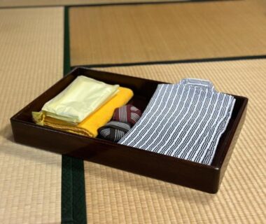 Folded yukata, obi and towel on a tray on tatami at Hotel Kosho Tochigi