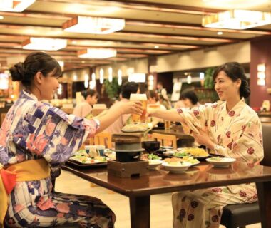 Two guests in yukata clinking glasses at a table with assorted dishes Hotel Koyokan Iwate